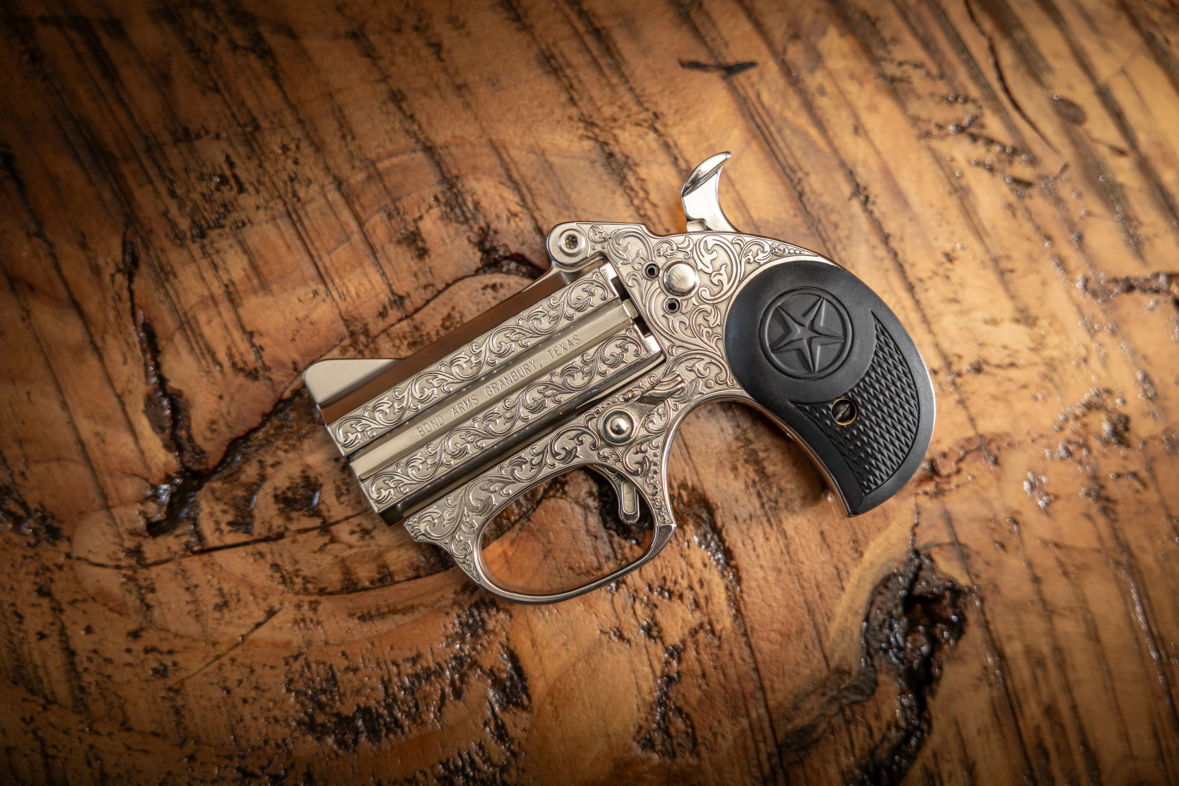Engraved Bond Arms derringer on wood