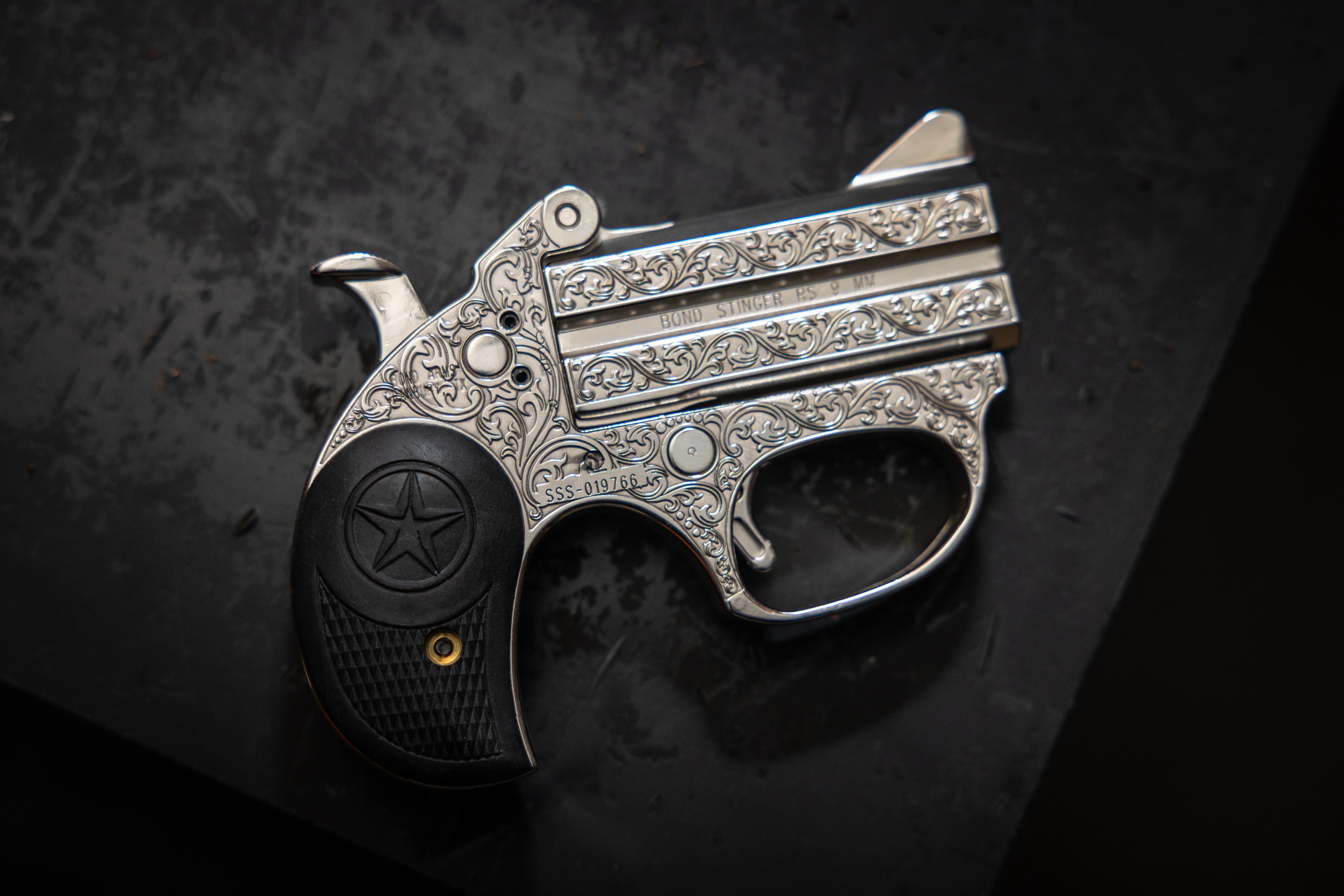 Engraved Bond Arms derringer on dark marble