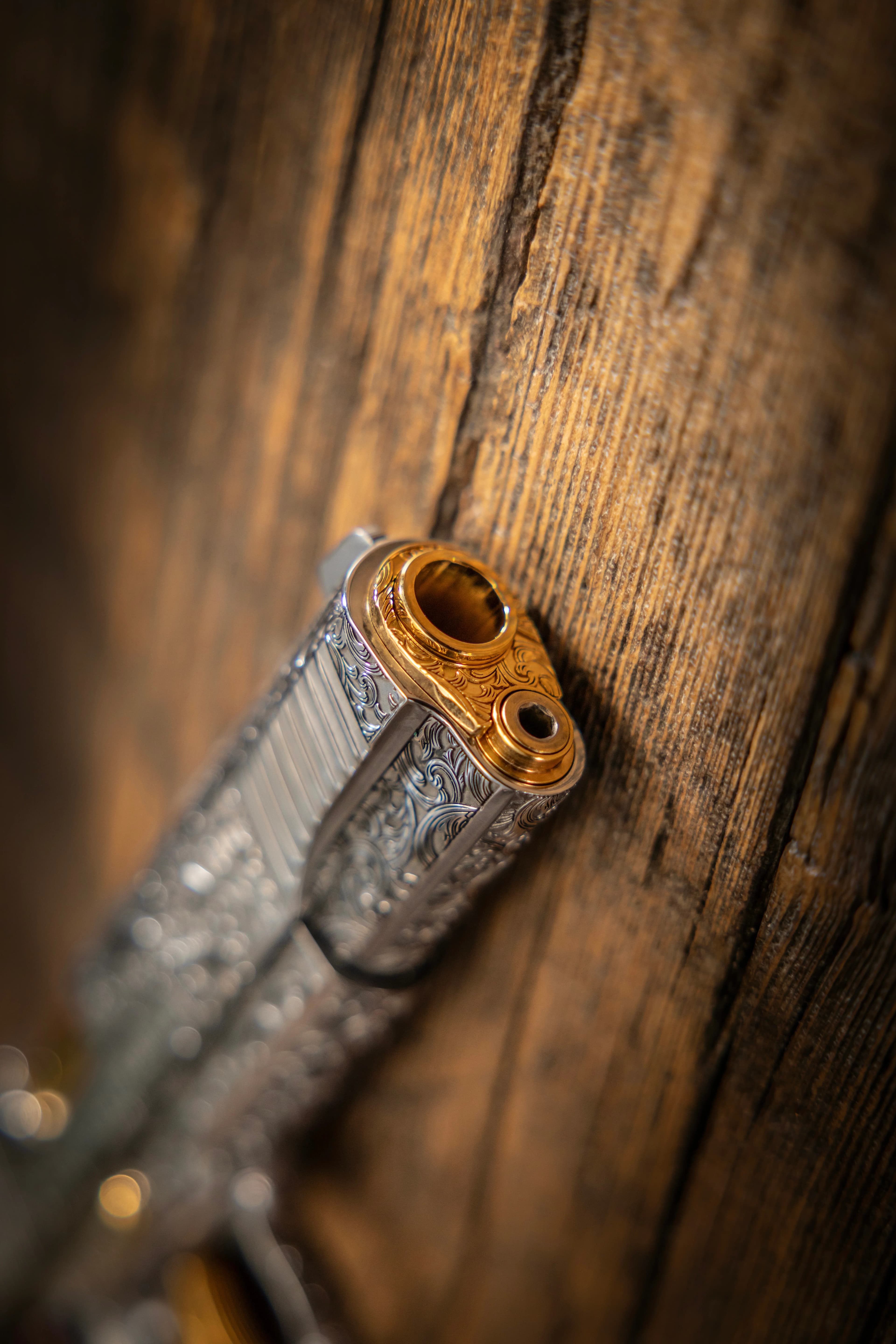 Jesus is King 1911 — gold barrel muzzle close-up on wood